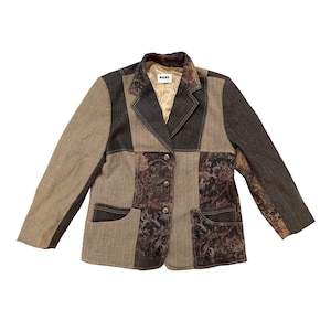 May include: A patchwork blazer in shades of brown, tan, and denim. The jacket has a notched collar, two front pockets, and three buttons. Floral patterned fabric is incorporated into the design. The brand name "WUCKE" is visible on the label.