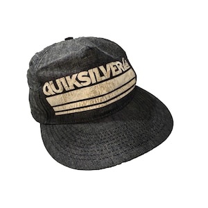 Gorra Quiksilver Y2K gris estilo campamento, snapback, surf, skate, streetwear, con logo desgastado.