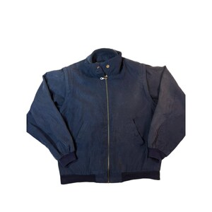 May include: A navy blue jacket with a full zipper closure, a stand-up collar, and two front pockets. The jacket has elastic cuffs and a hem. The jacket is made of a lightweight material.