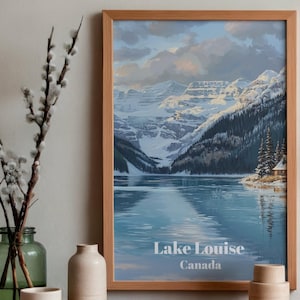 Può includere: Una stampa incorniciata del lago Louise in Canada, con un lago sereno che riflette montagne innevate e un cielo nuvoloso. L'opera d'arte è in una cornice di legno, con il testo "Lake Louise Canada" in basso. È un dipinto di paesaggio.