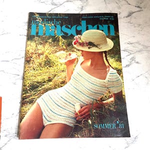 Peut inclure: Une couverture de magazine représentant une femme portant un maillot de bain en crochet rayé et un chapeau de paille. Le magazine est intitulé "modische maschen" et le texte "SOMMER '81" est imprimé en bas à droite.
