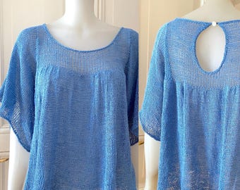 May include: A light blue knitted top with a keyhole back and short, ruffled sleeves.