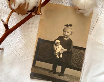 Carte postale ancienne nostalgique, petite fille avec sa poupée