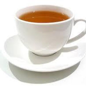 May include: A white ceramic teacup and saucer with a light brown tea inside.