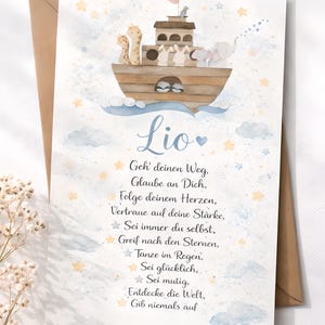 May include: A rectangular greeting card featuring a watercolor illustration of a wooden ark carrying giraffes, rabbits, and an elephant. The name Lio is printed above German text, surrounded by blue clouds and yellow stars on a white background.