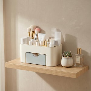 Puede incluir: Una taza de cerámica blanca con un asa negra y el texto "But First, Coffee" en negrita negra. La taza se encuentra sobre un fondo borroso, sugiriendo un ambiente acogedor.