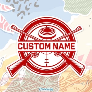 May include: A red and white sticker featuring a shooting sports design. The sticker has a circular emblem with crossed shotguns, a target, and the text "CUSTOM NAME". The design includes a clay target and a crosshair.