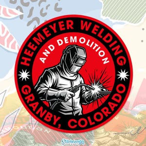 May include: A round sticker with a red border features the text "HEEMEYER WELDING AND DEMOLITION GRANBY, COLORADO" in white. A black and white illustration of a welder with a welding torch is in the center, with sparks emanating from the torch.