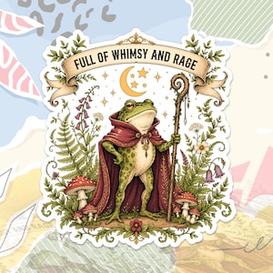 May include: A die-cut sticker featuring a green frog wearing a dark red cloak and holding a wooden staff. Above the frog is a banner with the text FULL OF WHIMSY AND RAGE, a crescent moon, and stars. The frog is surrounded by ferns, mushrooms, and flowers.