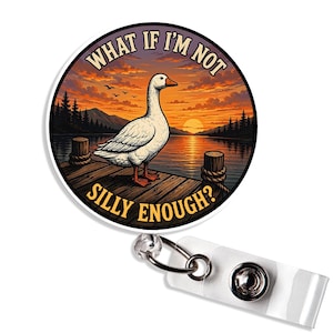 May include: A circular badge reel featuring a white goose standing on a wooden dock at sunset. The text "WHAT IF I'M NOT SILLY ENOUGH?" is printed in yellow capital letters along the top and bottom edges of the circular design.