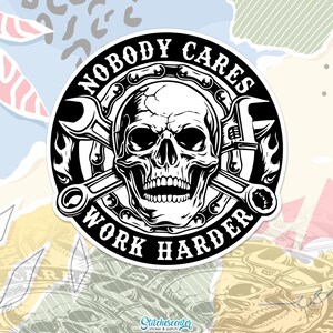May include: Black and white sticker featuring a skull with crossed wrenches. The text "NOBODY CARES WORK HARDER" is in a circular design around the skull. The sticker has a glossy finish and is likely for a car or motorcycle.