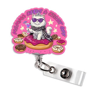 May include: A retractable badge reel with a pink background and the text "Momma Needs a Night Off". The reel features a cartoon cat wearing sunglasses, a scarf, and a crown, holding a cocktail while sitting on a donut. Several donuts surround the cat.