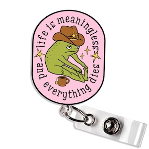May include: A pink badge reel with a cartoon frog wearing a cowboy hat. The frog is sitting and has a cup of tea. The text on the badge reel says "and life is meaningless dies everything".