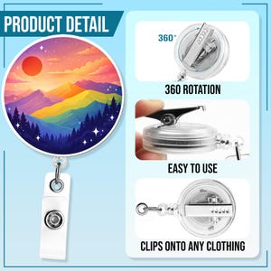 May include: A retractable badge holder with a round design featuring a colorful mountain landscape with a red sun. The holder has a white clip and a clear plastic reel. The text "360 ROTATION" and "CLIPS ONTO ANY CLOTHING" are visible.