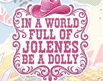 May include: A sticker featuring a pink glittery cowboy hat at the top and the text IN A WORLD FULL OF JOLENES BE A DOLLY in pink glittery lettering. The design is enclosed within a decorative pink glittery border with ornate scrollwork details.