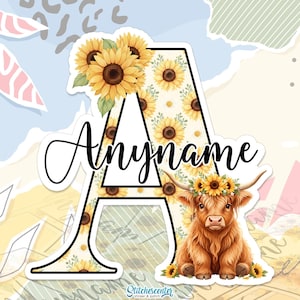 Peut inclure: Autocollant avec la lettre "A" décorée de tournesols et un fond aquarelle. La lettre contient le texte "Anymame" en écriture cursive. Une vache des Highlands avec une couronne de tournesols est en bas.