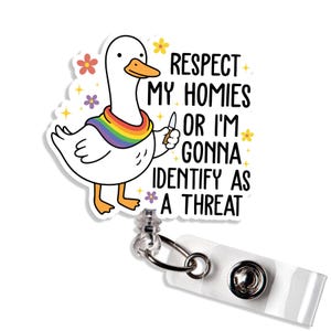 Peut inclure: Un enrouleur de badge blanc avec un dessin d'oie portant une écharpe arc-en-ciel et tenant un couteau. Le texte dit : « Respectez mes potes ou je vais m'identifier comme une menace ».