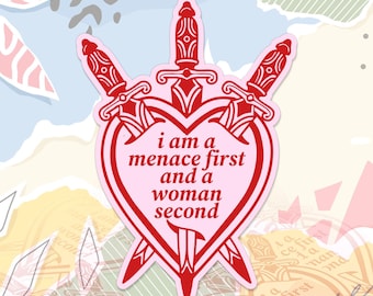 May include: A pink sticker with a red design. The design includes three swords and a heart shape. The heart contains the text "i am a menace first and a woman second". The sticker has a pink border.