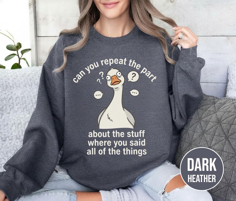 Puede incluir: Sudadera gris oscuro con una ilustraci&oacute;n de un ganso de dibujos animados y el texto "can you repeat the part about the stuff where you said all of the things." La sudadera tambi&eacute;n tiene el texto "DARK HEATHER".