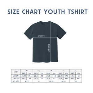 Puede incluir: Una camiseta juvenil de color verde azulado oscuro con una tabla de tallas. La tabla muestra las medidas en pulgadas y cent&iacute;metros para la longitud y el ancho, que van de la XS a la XL. Tambi&eacute;n se enumeran las tallas estadounidenses.