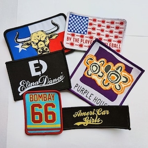 May include: A collection of six rectangular and square embroidered patches featuring various designs including a Texas longhorn, a pickleball flag with text, the Elina Dance logo, a Purple House graphic, a Bombay 66 sports patch, and AmeriCar Girls text.