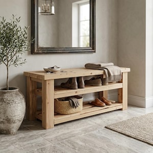 May include: A light-colored wooden entryway bench featuring two open shelves for storage. The top surface holds a small bowl and a folded beige throw blanket. The lower shelves contain a woven basket, a pair of brown shoes, and boots.