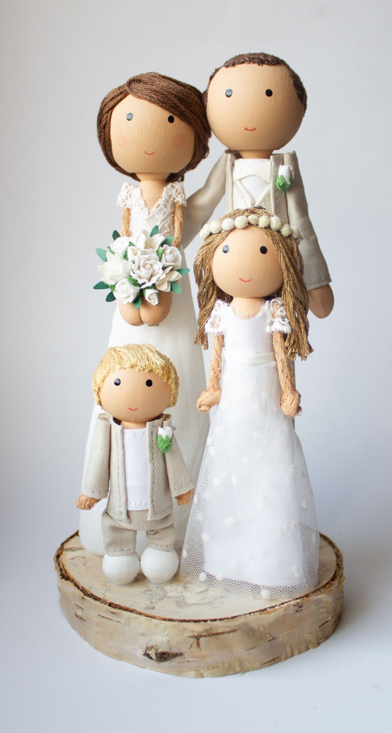 Tortenfiguren mit zwei Kindern vor dem Brautpaar stehend, für die Hochzeitstorte