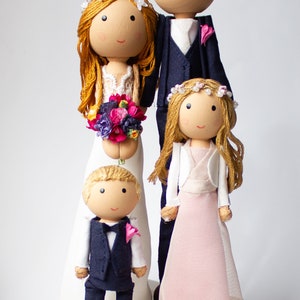 Tortenfiguren mit zwei Kindern vor dem Brautpaar stehend, für die Hochzeitstorte