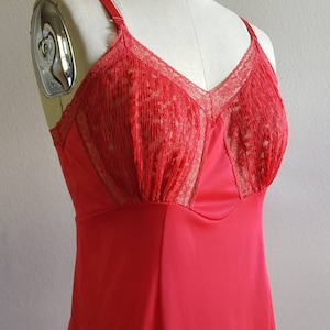 May include: A red slip dress with a lace bodice and adjustable straps. The dress is made of a silky material and has a fitted silhouette.