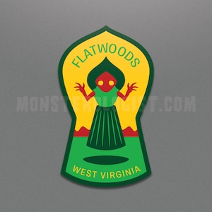 Pode incluir: Um autocolante colorido com o Monstro de Flatwoods da Virgínia Ocidental. O design inclui uma figura alienígena ruiva com os braços estendidos, um vestido verde e o texto "FLATWOODS WEST VIRGINIA". O autocolante tem a forma de um buraco de fechadura.