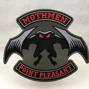 May include: A gray embroidered patch with a black creature with red eyes and wings. The patch has the text "Mothmen Point Pleasant" in red.