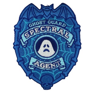 Puede incluir: Parche bordado azul y blanco con un fantasma, un murciélago y una telaraña. El texto dice "Ghost Guard Spectral Agent".