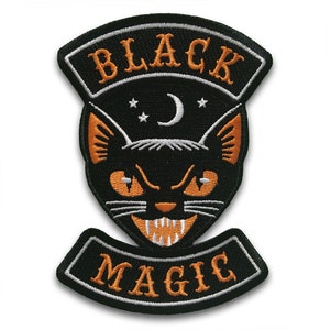 May include: Embroidered patch featuring a black cat with orange eyes and ears, a crescent moon, and stars. The patch has the words "BLACK" and "MAGIC" in orange lettering.
