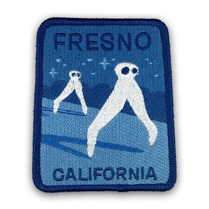 May include: Blue and white embroidered patch with the text "Fresno, California" and two white figures with large heads and long legs walking across a blue background.