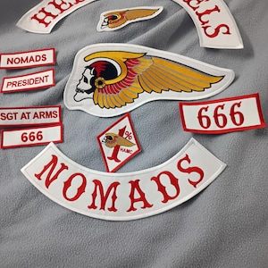 May include: A selection of embroidered patches. The patches display the words "HELLS ANGELS" and "NOMADS" in red on white. Other patches include a skull with wings, the number "666", and the text "SGT AT ARMS" and "PRESIDENT".