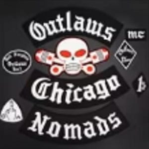 Op de afbeelding: Een verzameling zwarte en witte patches met de tekst "Outlaws mc", "Chicago Nomads" en andere insignes. Een centrale patch toont een schedel met rode ogen en gekruiste zuigers.