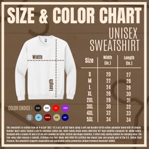 K&ouml;nnte beinhalten: Wei&szlig;es Unisex-Sweatshirt mit Gr&ouml;&szlig;en- und Farbtabelle. Die Tabelle zeigt die Ma&szlig;e in Zoll f&uuml;r die Gr&ouml;&szlig;en S bis 5XL. Farboptionen sind Schwarz, Wei&szlig;, Rot, Lila, Heather Grey, Sky, Maroon, Sand und Navy.