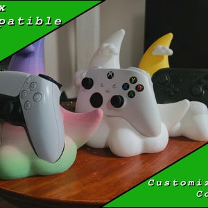 May include: Gaming controller stands in the shape of clouds, each holding a different controller. The stands are white with colorful accents, and the controllers are white and black. Text on the image reads "Xbox Compatible" and "Customizable Colors."