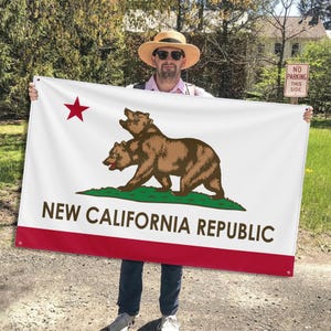 Puede incluir: Una bandera blanca con un borde rojo y una estrella roja en la esquina superior izquierda. La bandera presenta un diseño de oso marrón con el texto "NEW CALIFORNIA REPUBLIC" en negro.