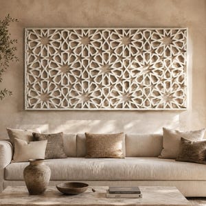 May include: A large rectangular wall panel featuring an intricate, repeating geometric star pattern in an off-white finish. The design consists of interconnected lines and polygons, creating a complex lattice structure mounted on a flat surface.