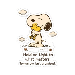 Puede incluir: Una pegatina troquelada que muestra a un perro de dibujos animados de color crema abrazando a un pequeño pájaro amarillo. El diseño incluye pequeñas nubes, flores y el texto: Hold on tight to what matters. Tomorrow isn't promised. Contorno marrón.