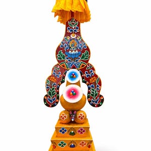 Könnte beinhalten: Ein aufwendiger, gelb-roter tibetisch-buddhistischer Opferständer. Der Ständer weist aufwendige bemalte Details auf, darunter florale Muster, religiöse Ikonografie und ein gelbes Stoffdach. Die Basis besteht aus gestapelten Plattformen.