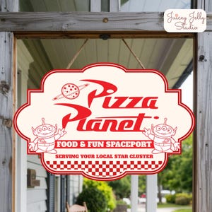 May include: A cream-colored Pizza Planet sign with red lettering and graphics. The sign features the words "Pizza Planet", two alien characters, and the text "FOOD & FUN SPACEPORT" and "SERVING YOUR LOCAL STAR CLUSTER". The sign is hanging by a rope.
