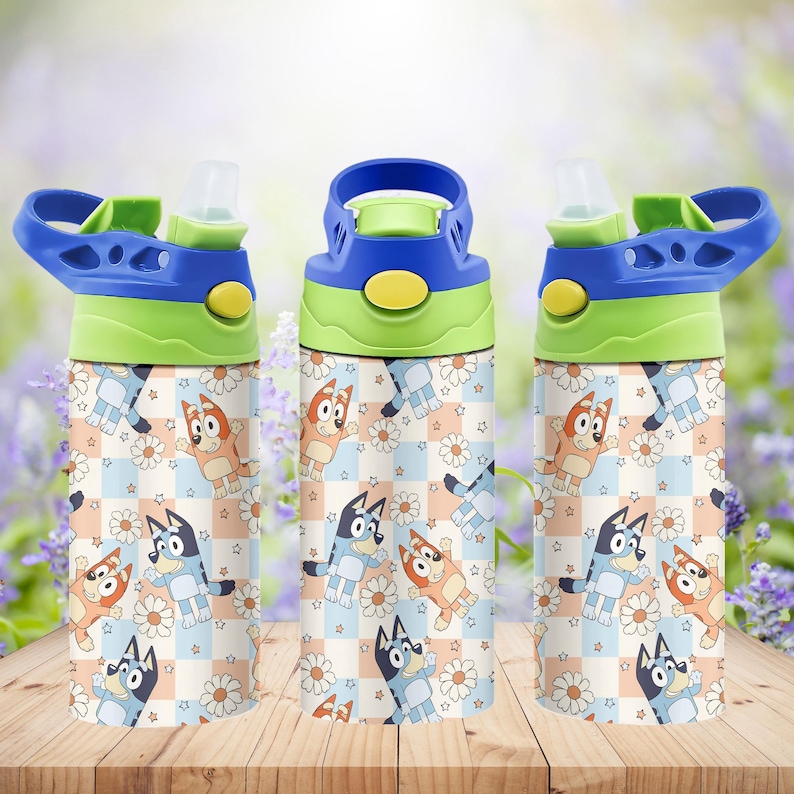 May include: Three water bottles with blue, green, and yellow lids. The bottles have a patterned design featuring cartoon characters, daisies, and stars on a checkered background. The bottles are on a wooden surface.