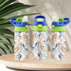 May include: Three water bottles with blue, green, and yellow lids. The bottles feature a repeating pattern of cartoon dogs, daisies, and stars on a checkered background. The bottles are on a wooden surface.