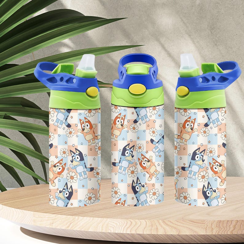 May include: Three water bottles with blue, green, and yellow lids. The bottles feature a repeating pattern of cartoon dogs, daisies, and stars on a checkered background. The bottles are on a wooden surface.