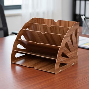 May include: A wooden desk organizer with a light brown wood grain finish. The organizer has four tiered compartments for storing documents and files. Decorative cutouts are on the sides. The organizer is on a brown desk.