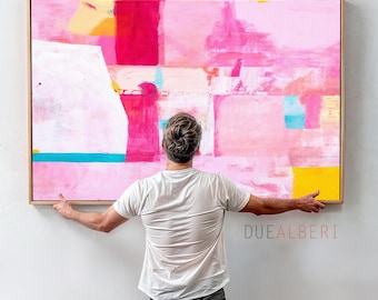Op de afbeelding: Een groot rechthoekig abstract schilderij in een lichthouten lijst met gelaagde blokken van felroze, magenta, witte, gele en turquoise verf. Het kunstwerk toont zichtbare penseelstreken en gestructureerde kleurvlakken. De tekst DUEALBERI is zichtbaar.