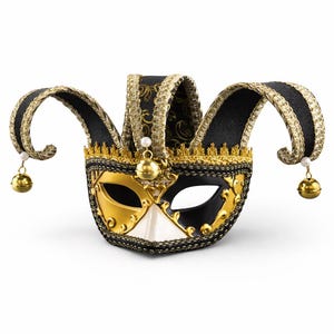 Könnte beinhalten: Eine dekorative venezianische Narrenmaske in Gold, Schwarz und Weiß. Die Maske hat ein geteiltes Design, wobei eine Seite goldfarben und die andere schwarz ist. Sie hat dekorative goldfarbene Verzierungen, schwarze Stoffakzente und hängende goldfarbene Glöckchen.