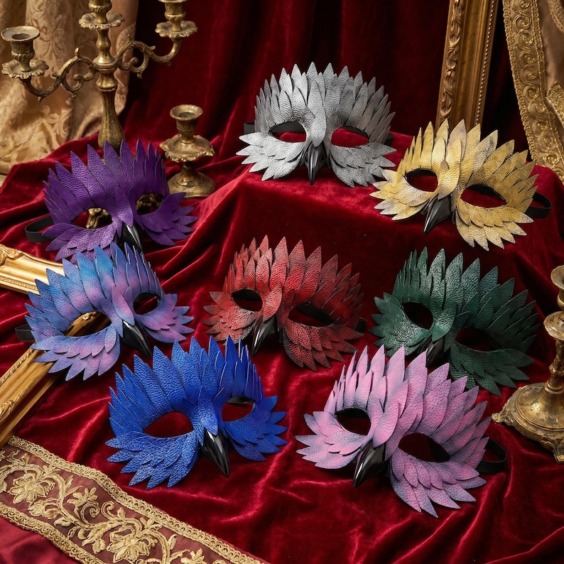 May include: A selection of bird-themed masks in a range of colours, such as purple, blue, red, green, and gold. Each mask has a detailed feather design and a black beak, suitable for costume parties or theatrical performances.